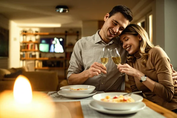 Happy Couple Embracing Toasting Champagne While Having Dinner Dining Table — стоковое фото
