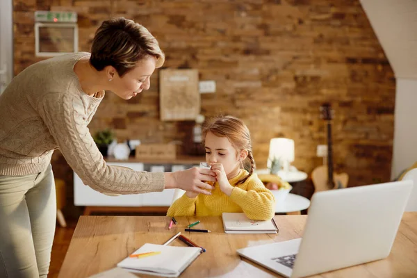 Caring Mother Giving Her Daughter Refreshment While Homeschooling — Foto de Stock