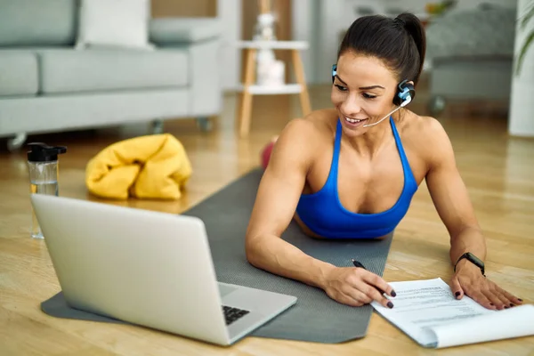 Young Smiling Athlete Using Computer Taking Notes While Making Her —  Fotos de Stock