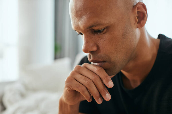 Close-up of distraught African American man thinking of something at home.