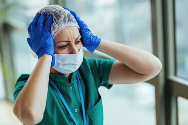 진료소에서 통증으로 머리를 감싸고 보호용 작업복을 스러워 간호사들 — 스톡 사진