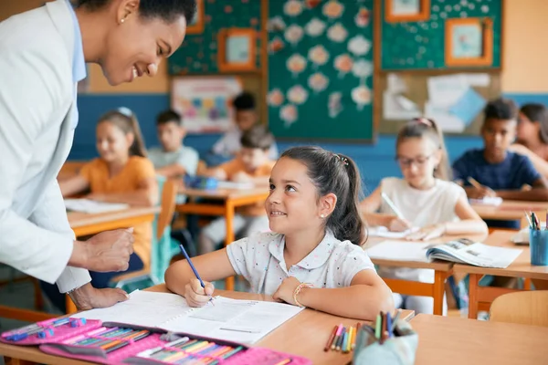 Happy Elementary Student Communicating Teacher Who Assisting Her Lecture Class — Foto de Stock