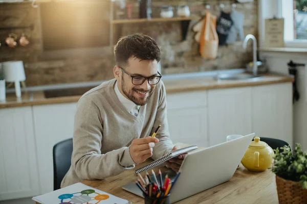 Boldog Férfi Vállalkozó Olvasás Jegyzetek Miközben Dolgozik Laptop Otthon — Stock Fotó