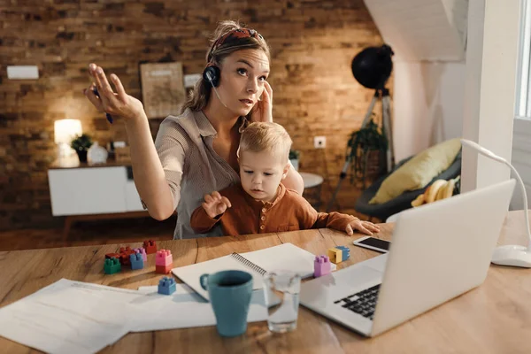 Single Mother Talking Headset While Working Taking Care Her Son — Φωτογραφία Αρχείου