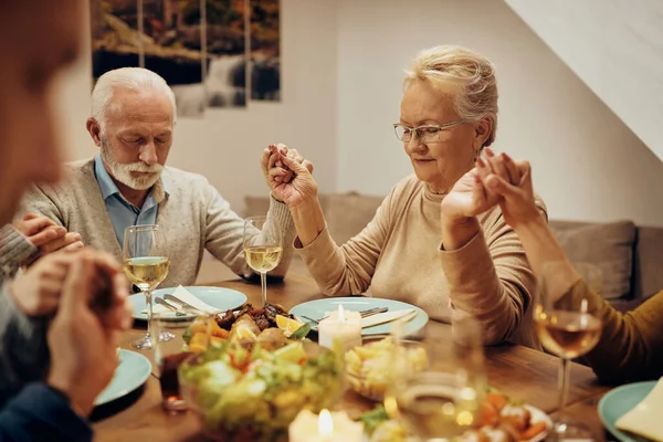 Mature Woman Holding Hands Her Family While Saying Grace Meal — Stock fotografie