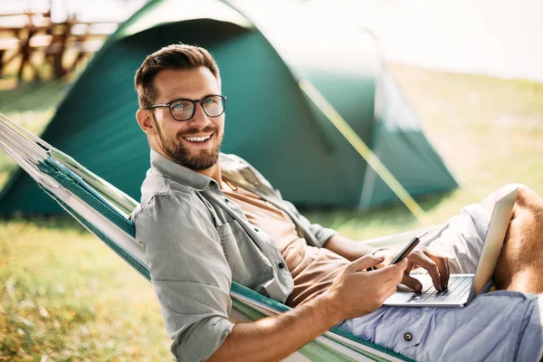 Happy Camper Using Laptop While Texting Mobile Phone Relaxing Hammock — Stok fotoğraf