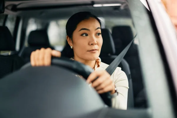 Young Asian Woman Looking Away While Driving Car — 图库照片