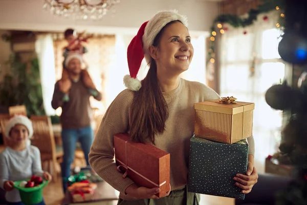 Happy Woman Holding Wrapped Gifts While Celebrating Christmas Her Family — Stock fotografie