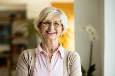 Portrait of happy mature woman looking at camera at home. 