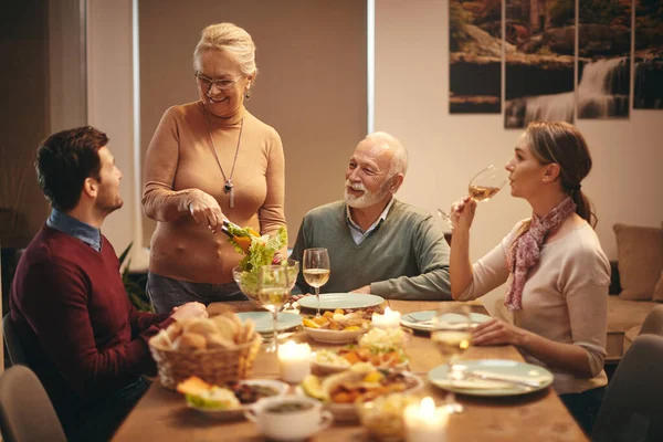 Happy Mature Woman Talking Her Family While Serving Food Table — ストック写真