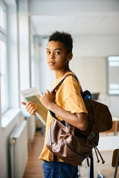 African American Schoolboy Backpack Books Standing Classroom Looking Camera — Foto de Stock