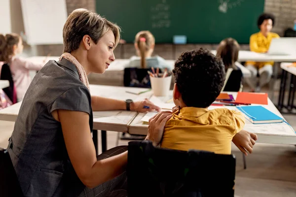 Female Teacher Talking Her Elementary Student While Helping Him Assignment — ストック写真