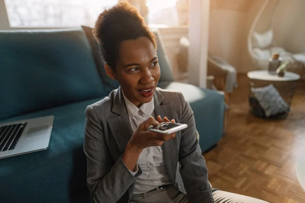Black Smiling Businesswoman Recording Voice Message Smart Phone While Working — Fotografia de Stock