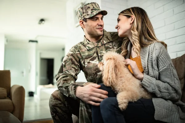 Young happy veteran talking to his wife while coming home from military assignment.
