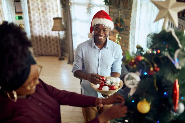 Happy African American Man Decorating Christmas Tree His Wife Home — ストック写真