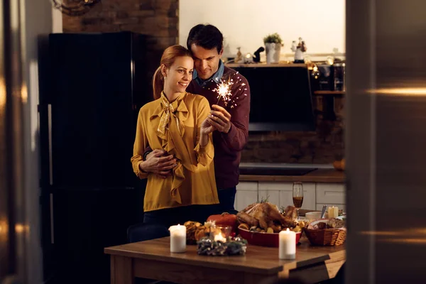 Affectionate Couple Embracing Using Sparkler Thanksgiving Dinner Dining Room —  Fotos de Stock