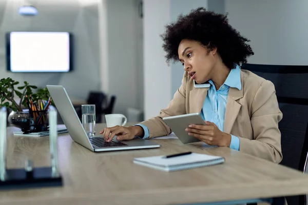 Multi Tasking Black Businesswoman Working Laptop While Using Touchpad Talking — Photo