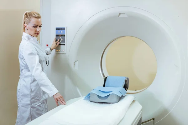 Female doctor with MRI scanner in medical examination room at the hospital.