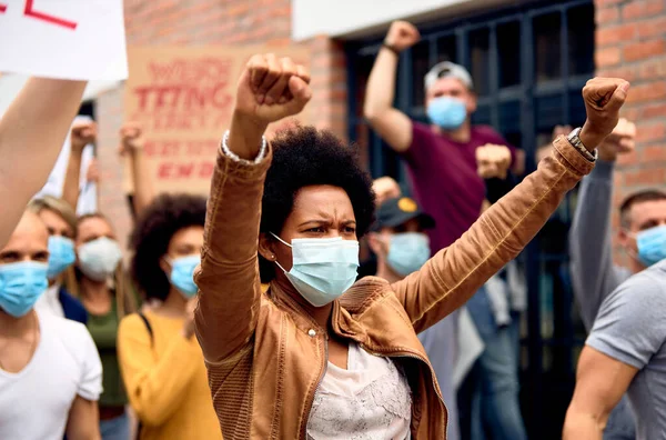 Black Woman Raised Fists Wearing Protective Face Mask While Supporting — 图库照片
