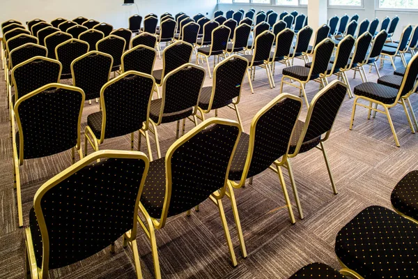 Back view of chairs in a row with no people at conference hall.