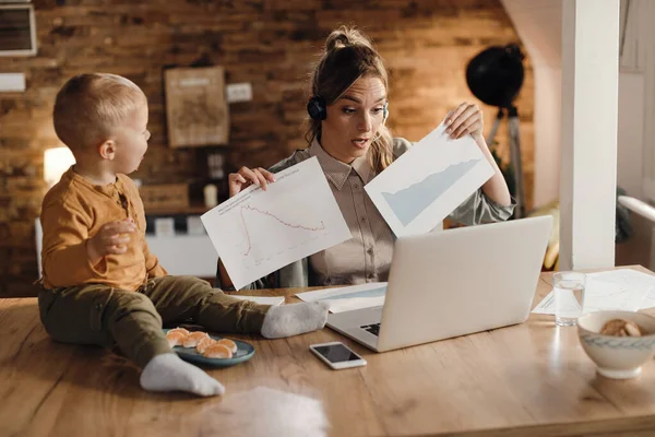 Working Mother Using Laptop Examining Business Graphs While Having Video — Φωτογραφία Αρχείου