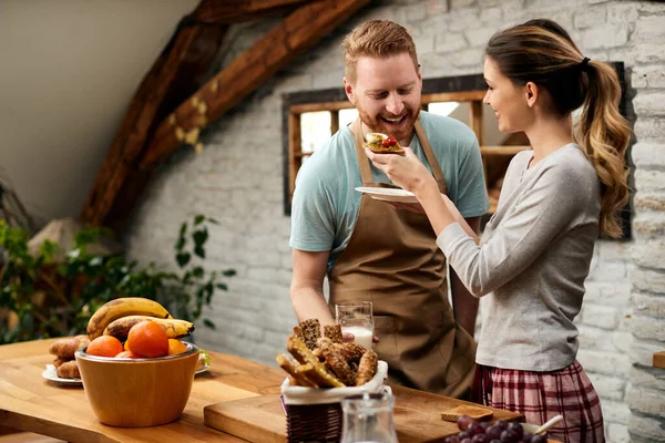 Happy Woman Feeding Her Boyfriend While Having Breakfast Morning Together — Stockfoto
