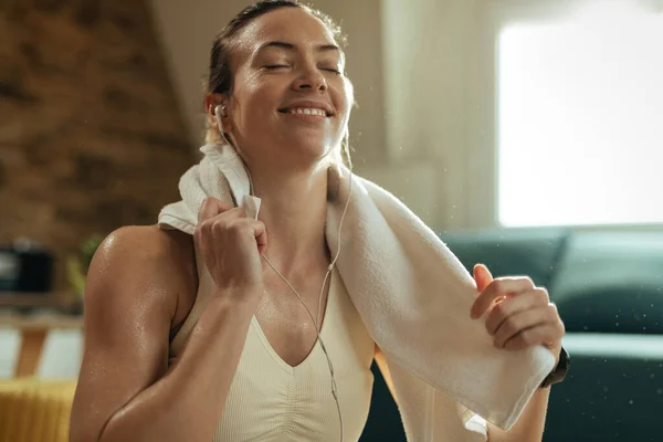 Happy Female Athlete Wiping Her Sweat While Taking Break Listening — Φωτογραφία Αρχείου
