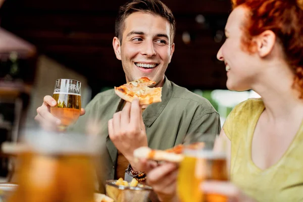 Young Happy Couple Eating Pizza Drinking Beer While Talking Pub — Foto de Stock