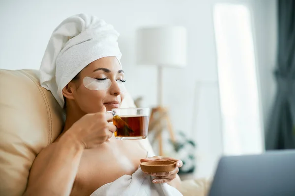 Young Woman Hydrogel Eye Recovery Patches Drinking Detox Tea Home — 스톡 사진