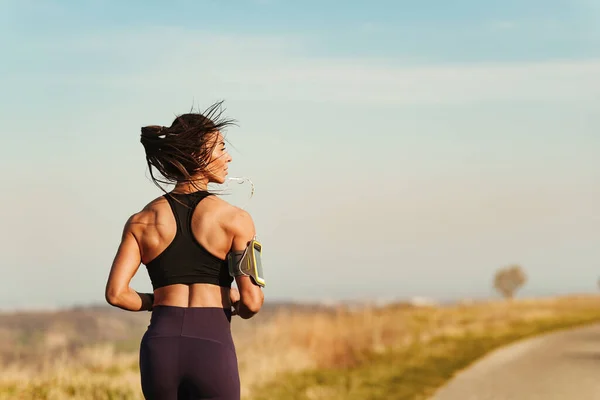 Back View Athletic Woman Jogging While Exercising Nature Copy Space — Fotografia de Stock