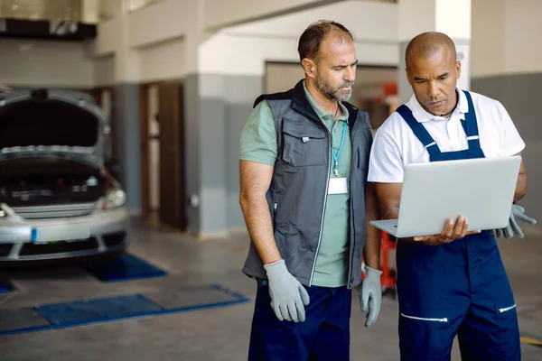 African American Car Mechanic His Coworker Using Laptop While Working — ストック写真