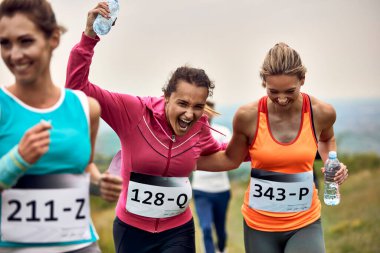 Cheerful runners having fun while participating in a race in nature. 