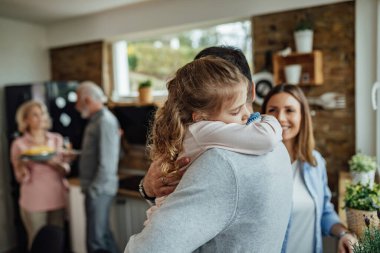 Affectionate daughter embracing her father with eyes closed.
