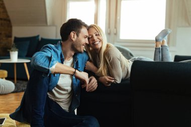 Mutlu çift oturma odasında dinlenirken sevgi gösteriyor.. 