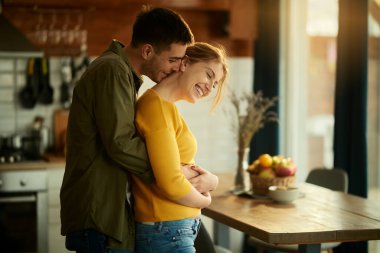 Young couple embracing and having fun together at home. 