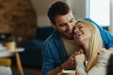 Happy couple in love showing affection towards each other at home.
