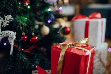 Close-up of red gift box under the Christmas tree at home. 