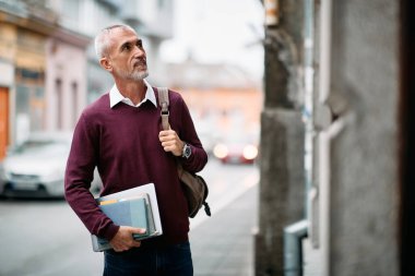 Smiling mature man coming to university library to study.