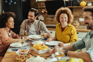 Happy redhead woman and her friends enjoying in lunch at dining table. 