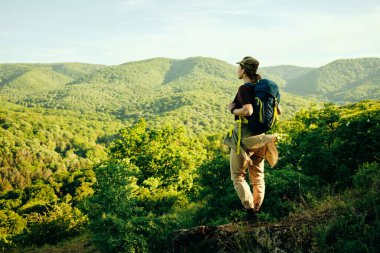 Sırt çantalı bir kadın doğa yürüyüşü yaparken ormanın tadını çıkarıyor.. 