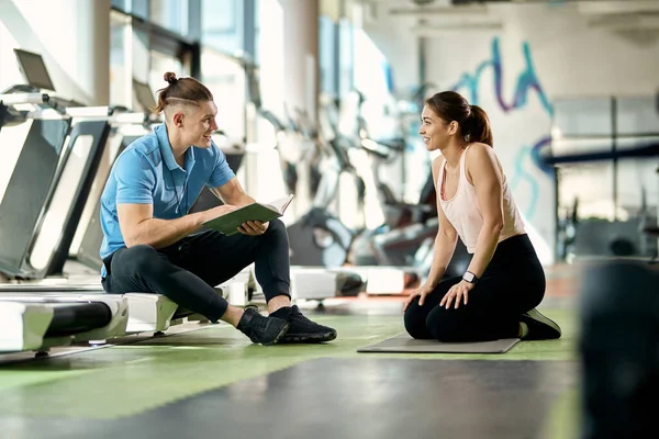 Happy Male Coach Communicating Sportswoman Who Taking Break Exercising Gym — Stockfoto
