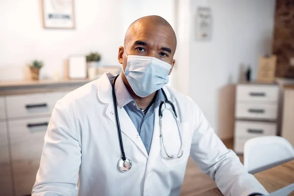 Portrait of African American medical expert wearing protective face mask at doctor\'s office and looking at camera.