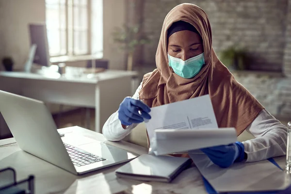 Black Islamic Businesswoman Wearing Protective Face Mask While Going Paperwork — Foto Stock