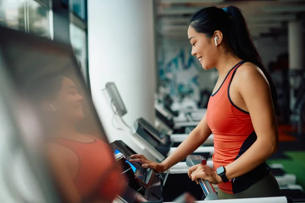 Young Asian Athletic Woman Adjusting Speed Treadmill While Exercising Gym — стоковое фото