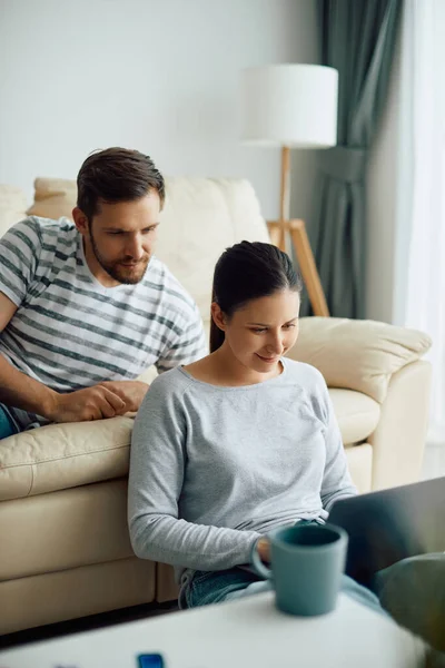 Smiling Woman Using Laptop While Relaxing Her Husband Home — Foto de Stock