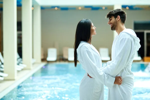 Young Happy Couple Bathrobes Standing Swimming Pool Talking Each Other — стоковое фото