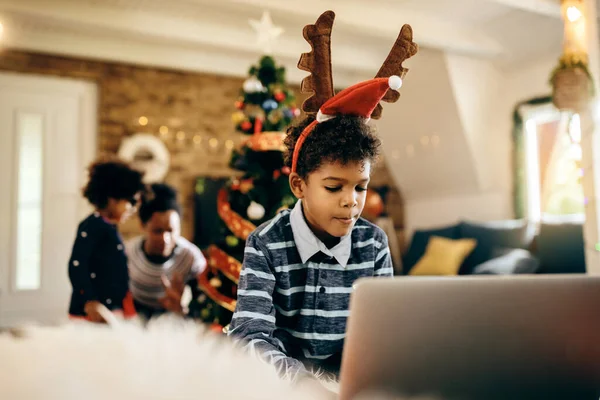 African American Boy Surfing Net Laptop While Spending Christmas His — ストック写真
