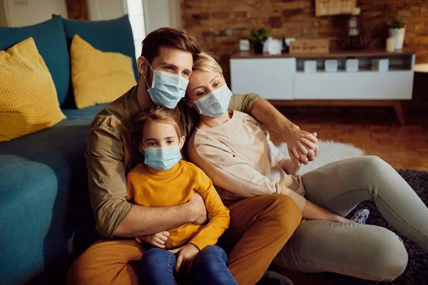 Family wearing face masks while relaxing at home during coronavirus pandemic.
