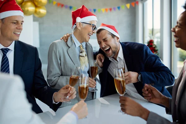 Happy business people laughing and having fun while drinking Champagne on New Year\'s party in the office.