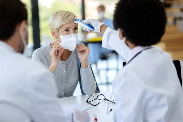 Mature Woman Wearing Protective Face Mask While Doctor Measuring Her — 스톡 사진